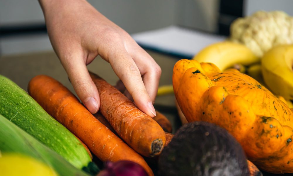 closeup-woman-s-hand-takes-carrot-cooking